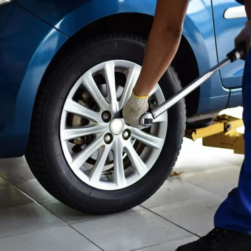 Fitter tightening a wheel nut with a torque wrench